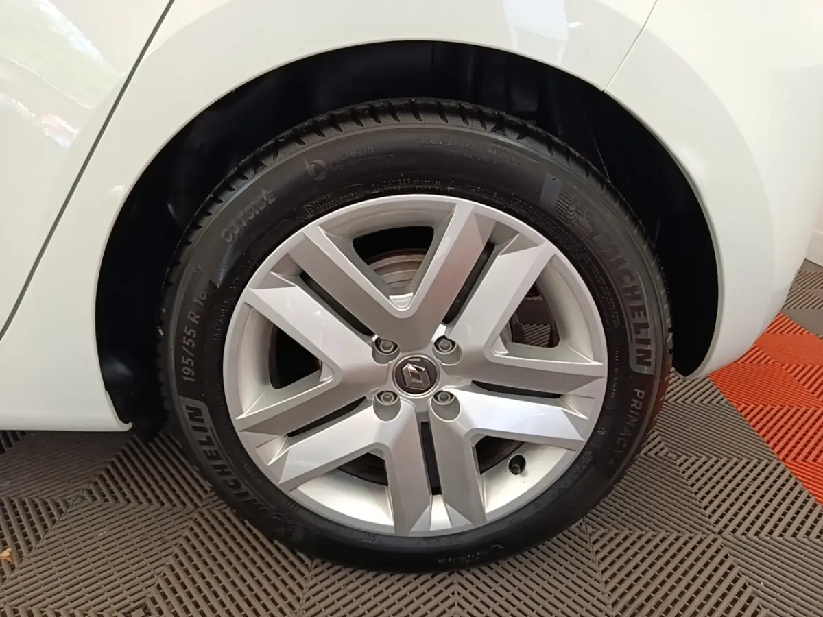 Gros plan sur la roue avant droite blanche d'une Renault Clio Business E-TECH 140 avec jante alliage et pneu Michelin.