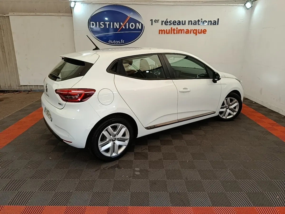 Renault Clio Business E-TECH 140 blanc vue 3/4 arrière droit, avec jantes alliage et logo Distinxion en arrière-plan.