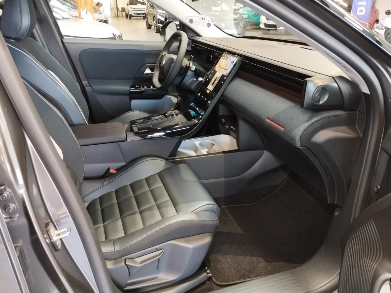 Vue intérieure côté passager avant du Citroën C5 Aircross gris platine, avec sièges cuir noir et écran tactile vertical.