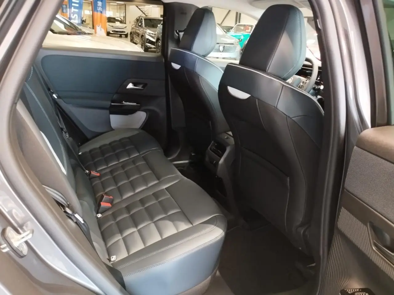 Vue intérieure arrière côté gauche du Citroën C5 Aircross gris platine, sièges en cuir noir matelassé et finitions modernes.