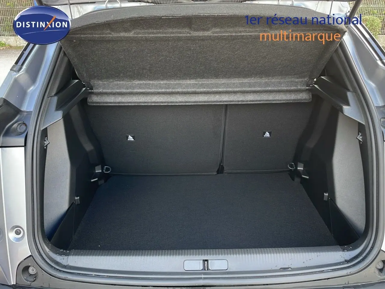 Coffre ouvert d'un Peugeot 2008 gris Artense Metal, vue arrière montrant l'espace de chargement vide.