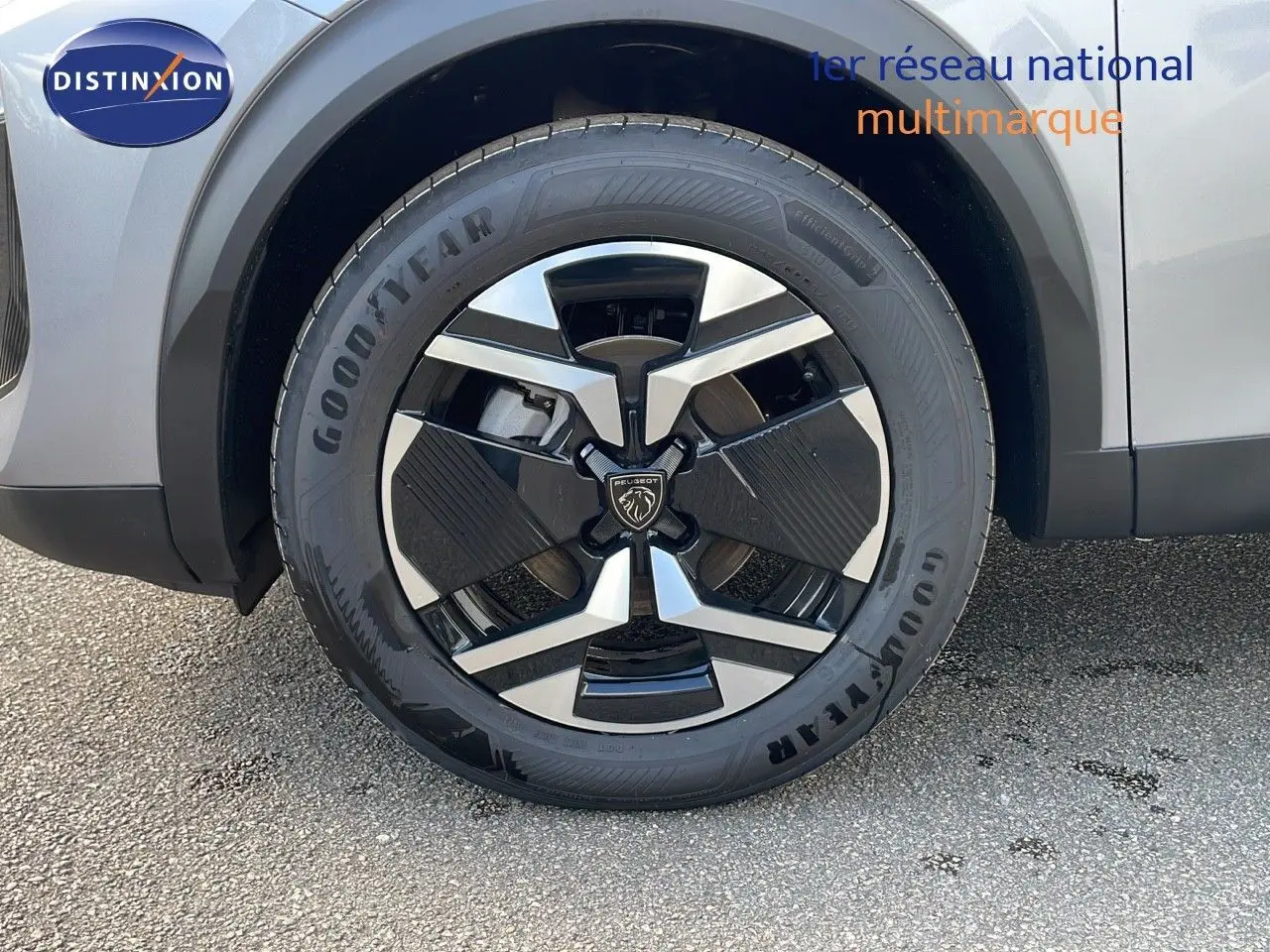 Gros plan sur la roue avant gauche d'un Peugeot 2008 gris Artense avec jante alliage noire et argent.