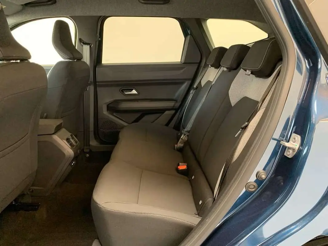 Vue intérieure côté droit sur la banquette arrière grise du Dacia Bigster Hybrid 155 Journey Plus bleu indigo.