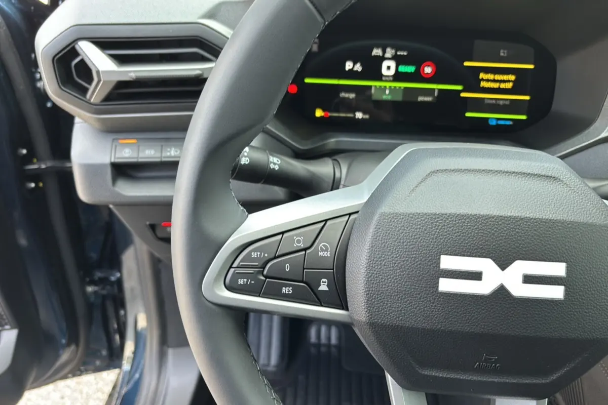 Vue rapprochée du volant cuir et du tableau de bord digital du Dacia Bigster Hybrid 155 Journey Plus bleu indigo.