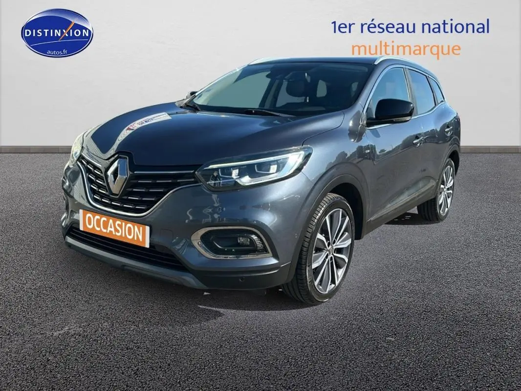 Renault Kadjar gris foncé vu en 3/4 avant droit, avec jantes alliage 19 pouces et feux allumés.