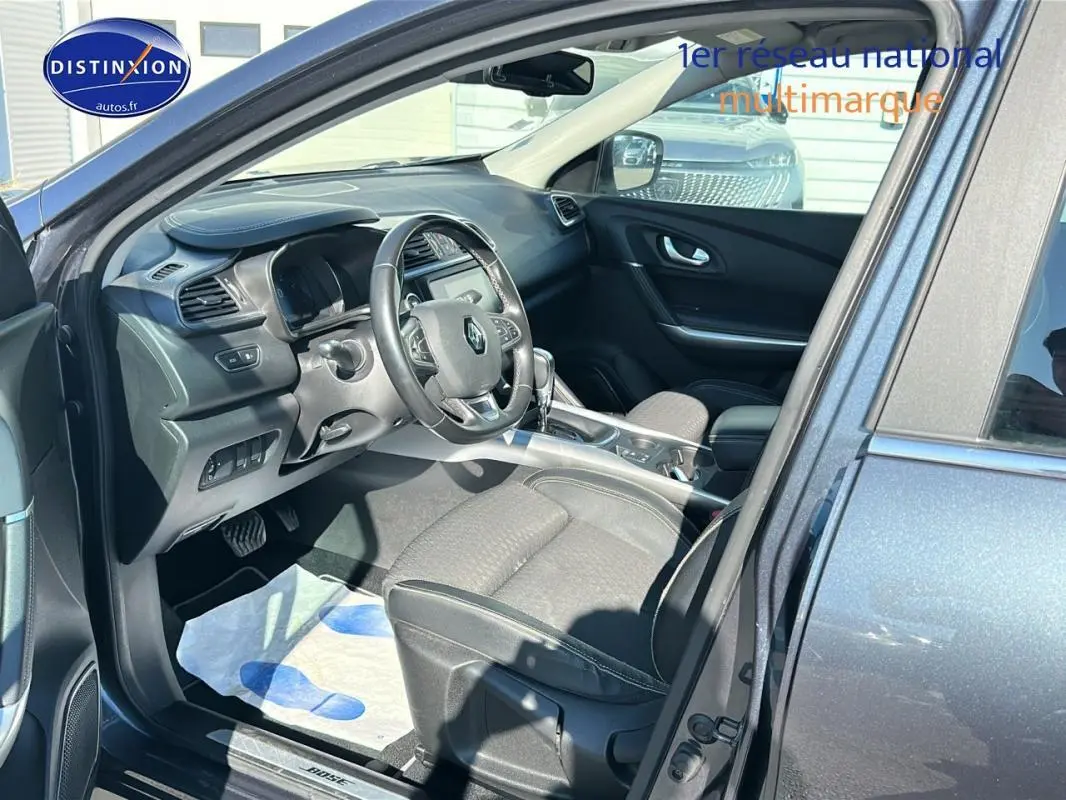 Intérieur du Renault Kadjar gris foncé vu côté conducteur, volant cuir et écran tactile au tableau de bord.