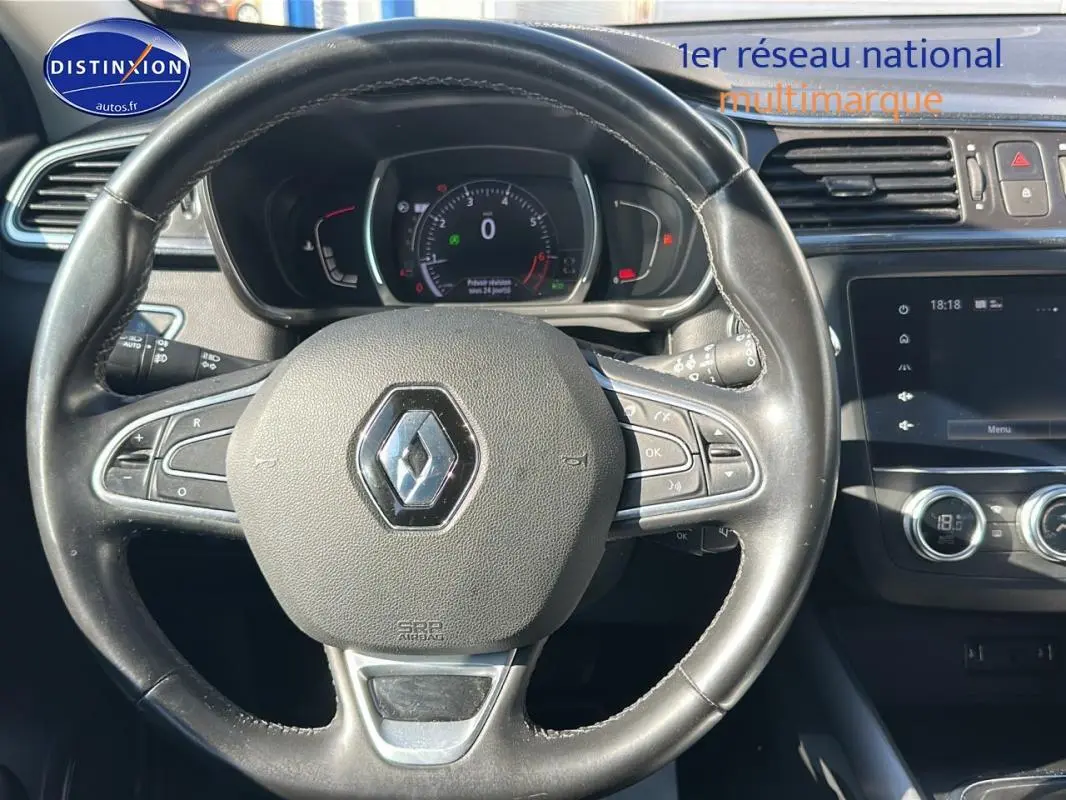 Vue rapprochée du volant cuir et du tableau de bord du Renault Kadjar gris foncé avec écran tactile et commandes au volant.