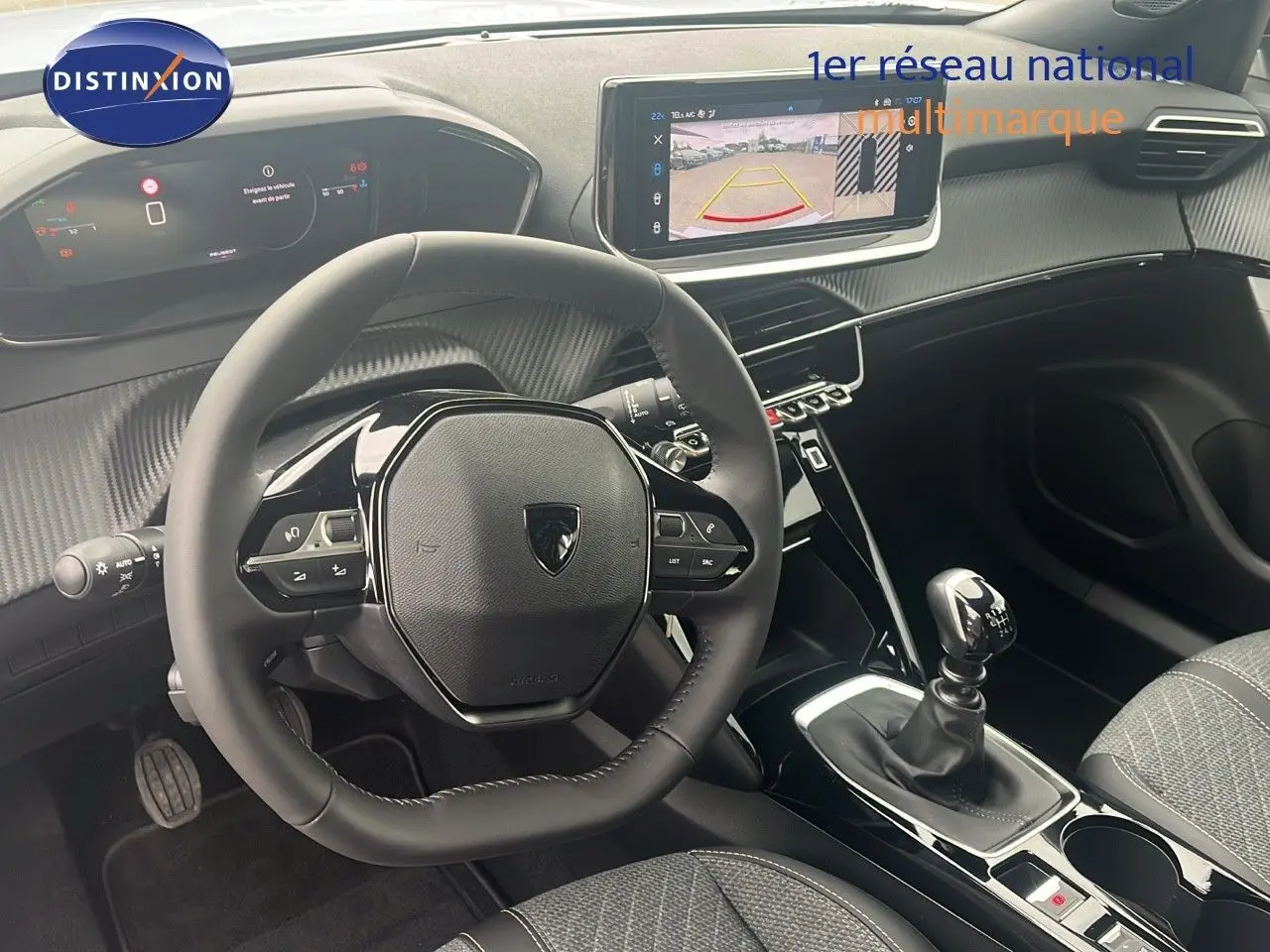 Intérieur de la Peugeot 2008 2025, vue du poste de conduite avec volant, écran tactile et levier de vitesse manuel.
