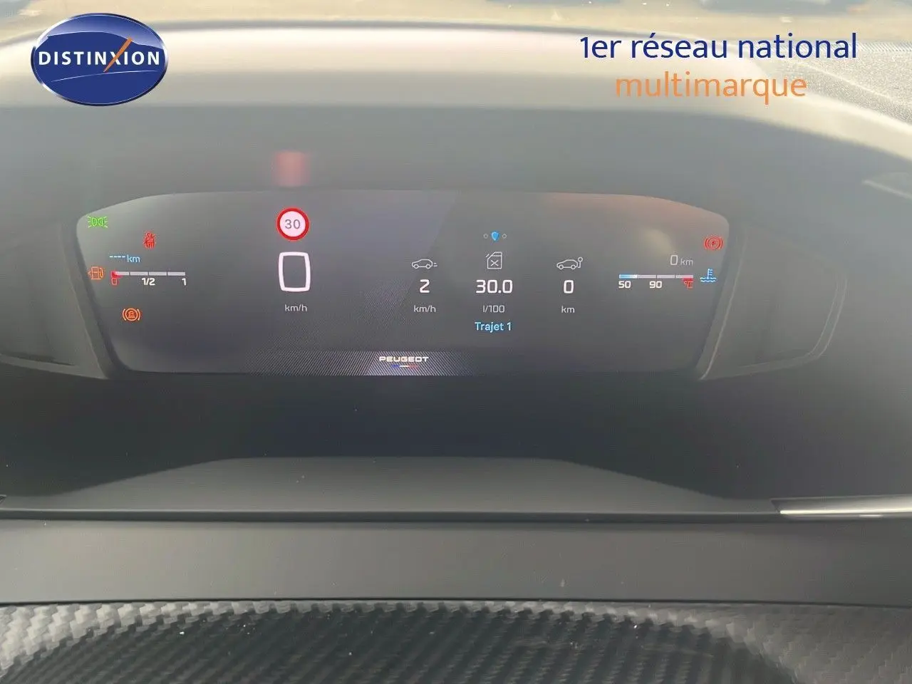 Affichage numérique du tableau de bord du Peugeot 2008 blanc, montrant la vitesse, consommation et indicateurs divers.