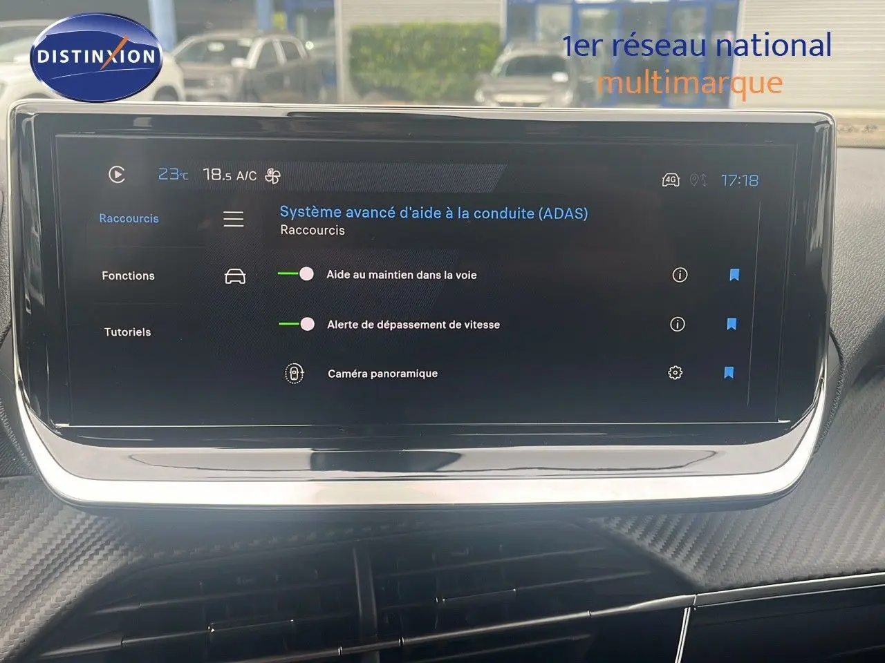 Écran tactile central du Peugeot 2008 blanc, affichant les aides à la conduite et la caméra panoramique.