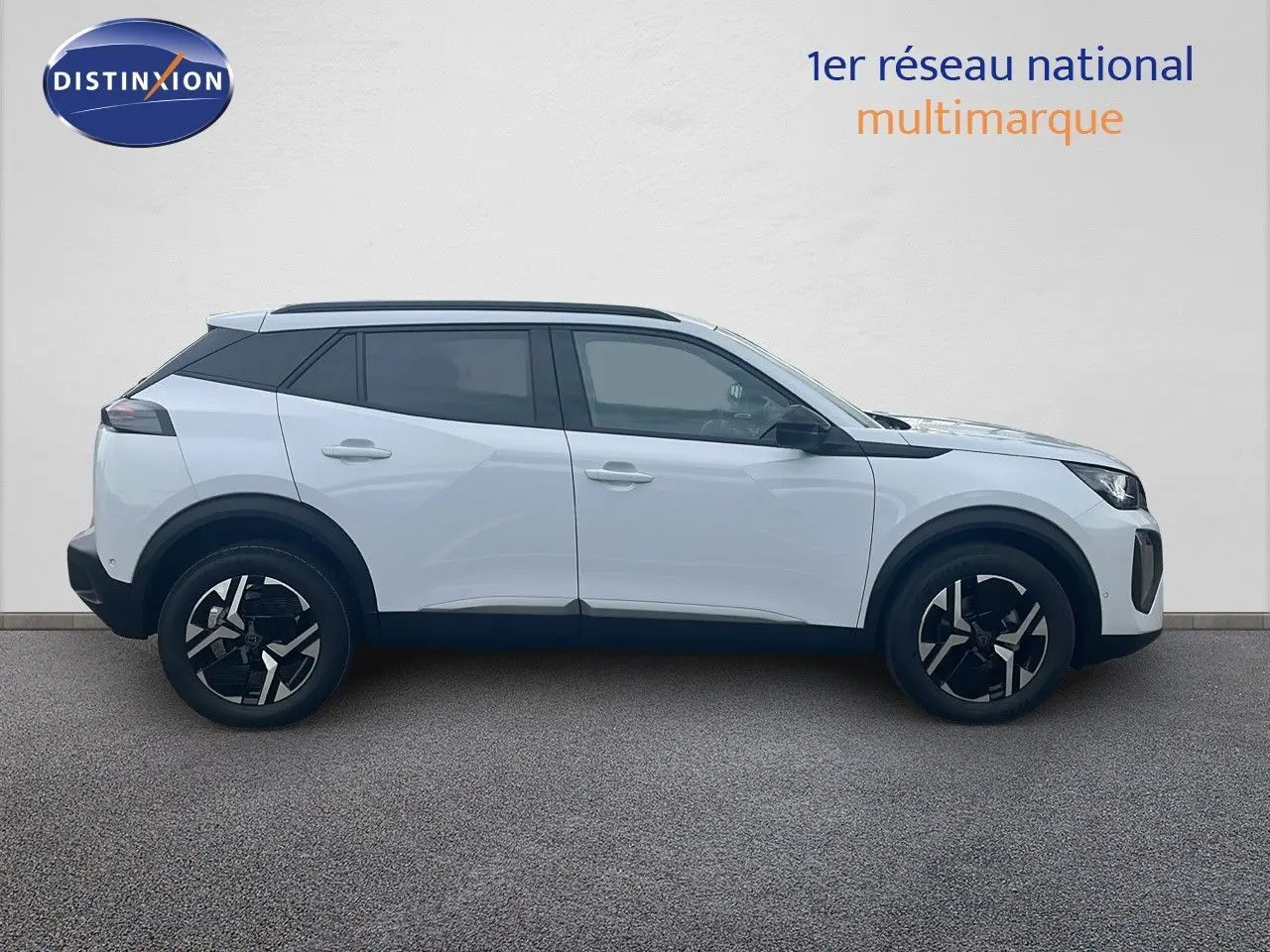 Profil côté gauche d'un Peugeot 2008 blanc Okenite métal de 2025 avec jantes noires et toit noir contrasté.