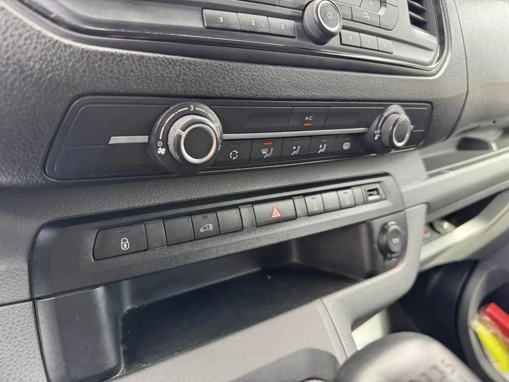 Détail de la console centrale noire du Peugeot Expert Fourgon 2018, montrant les commandes de climatisation et les boutons de fonction.