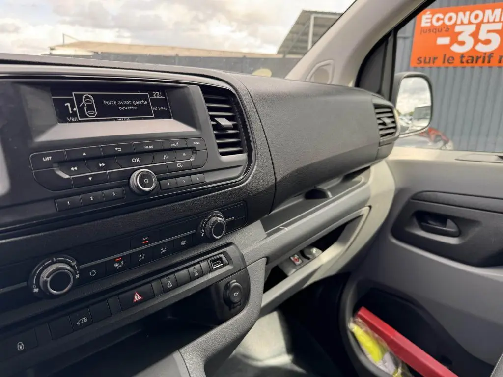 Tableau de bord et console centrale du Peugeot Expert Fourgon blanc, vue intérieure côté passager avec écran et commandes visibles.