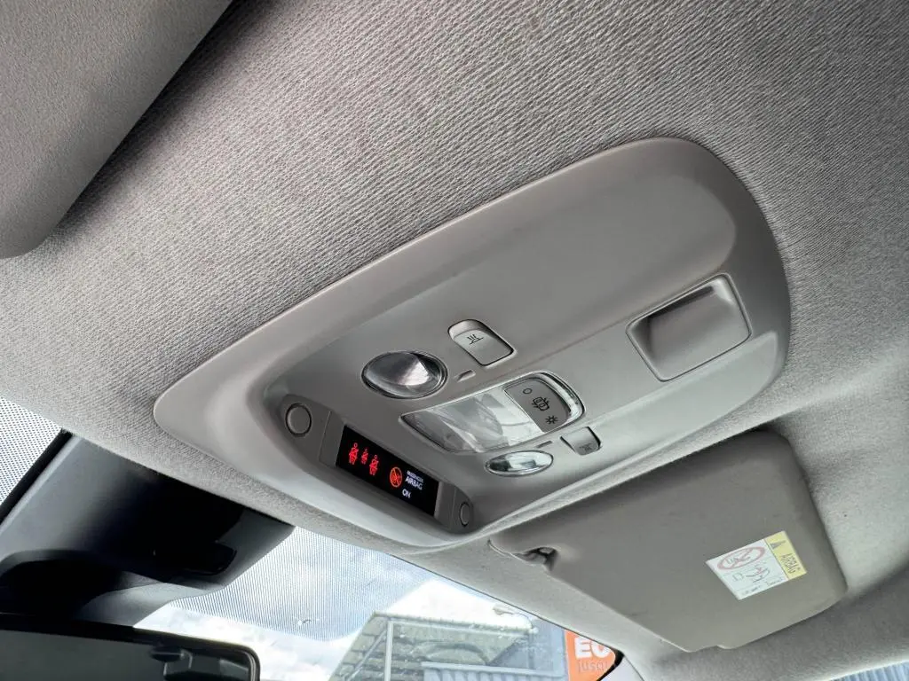 Vue intérieure du plafonnier gris clair du Peugeot Expert Fourgon blanc, avec commandes d'éclairage et affichage LED rouge.