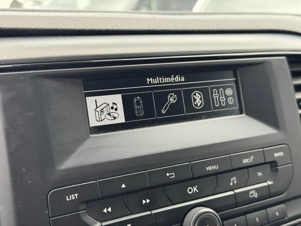 Écran multimédia du tableau de bord du Peugeot Expert Fourgon blanc, affichant les options audio et Bluetooth.