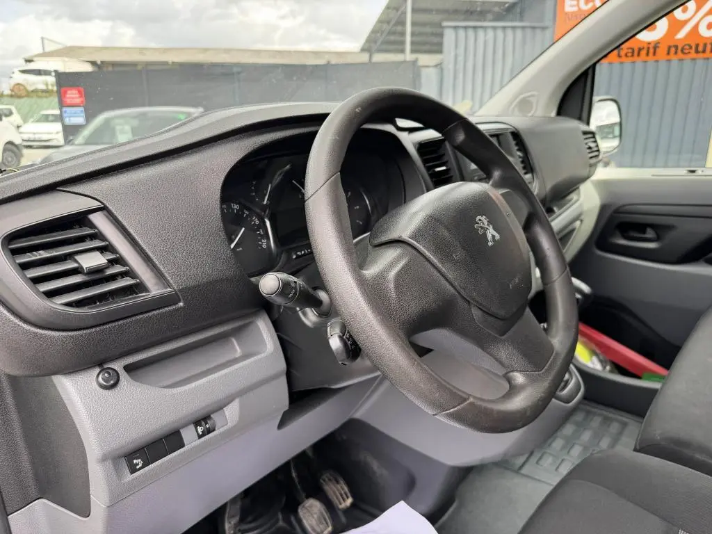 Vue intérieure côté conducteur du Peugeot Expert Fourgon 2018, volant noir et tableau de bord gris foncé.