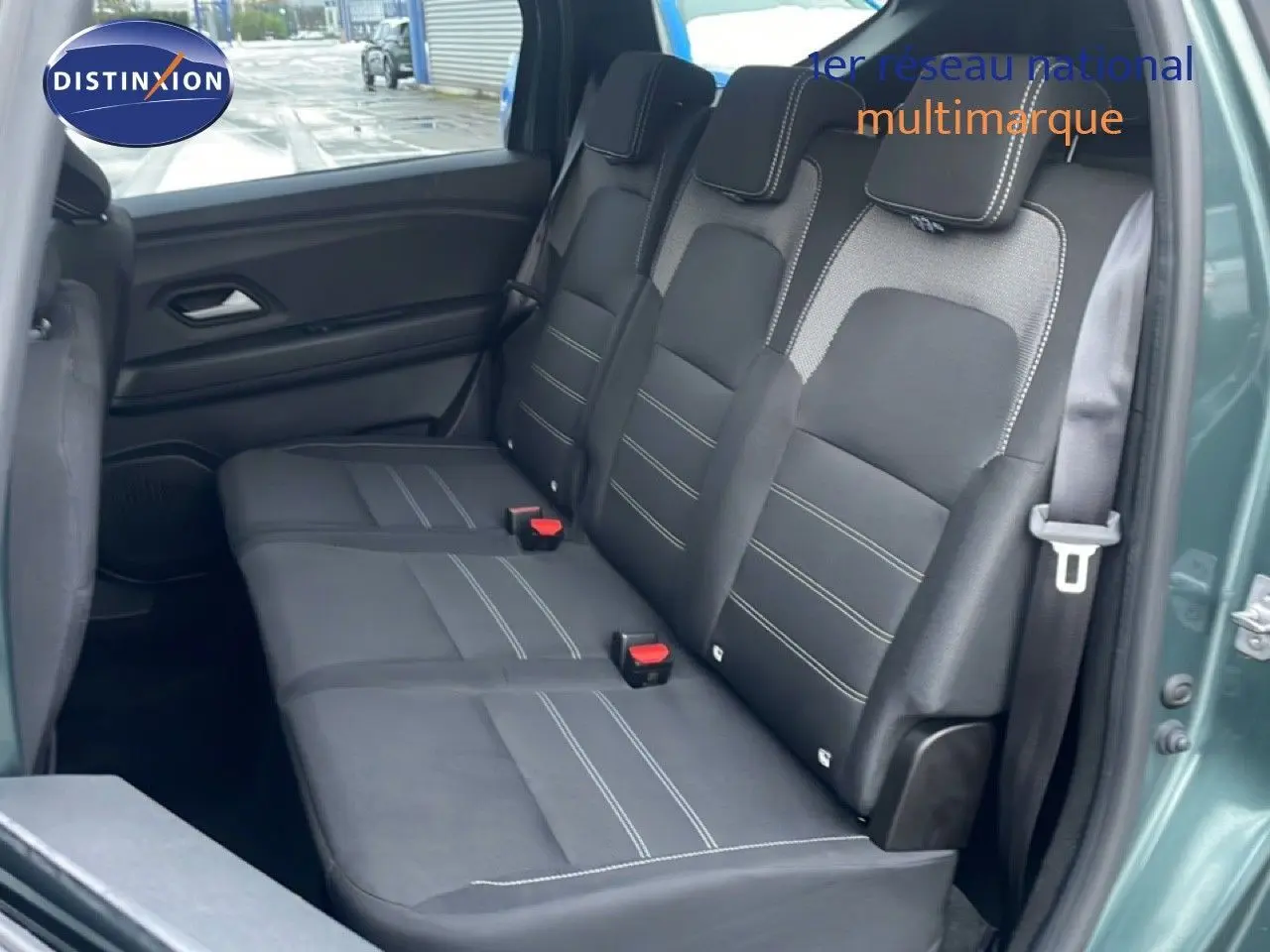 Gros plan sur la console centrale noire du Dacia Jogger 2025, montrant les commandes de climatisation et les voyants de sécurité.