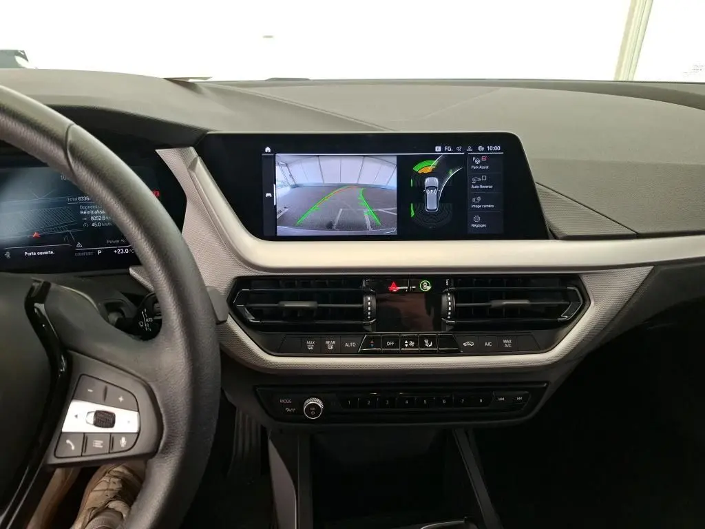 Vue intérieure du tableau de bord de la BMW Série 1 116d 2022 avec écran central affichant la caméra de recul.