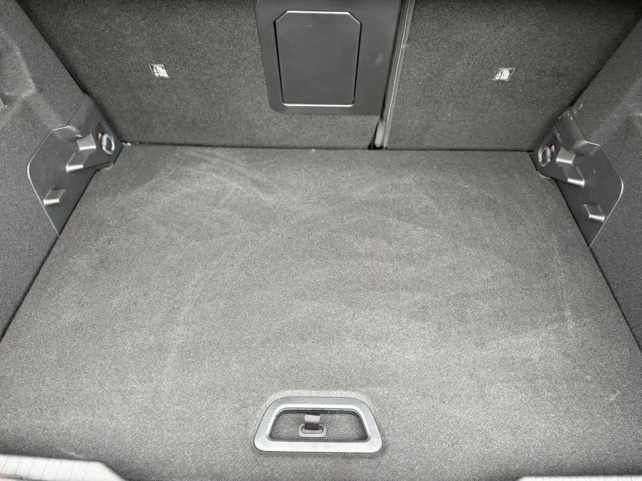 Vue plongeante sur le coffre spacieux et tapissé de tissu gris foncé de la Citroën C4 Hybrid 2025.
