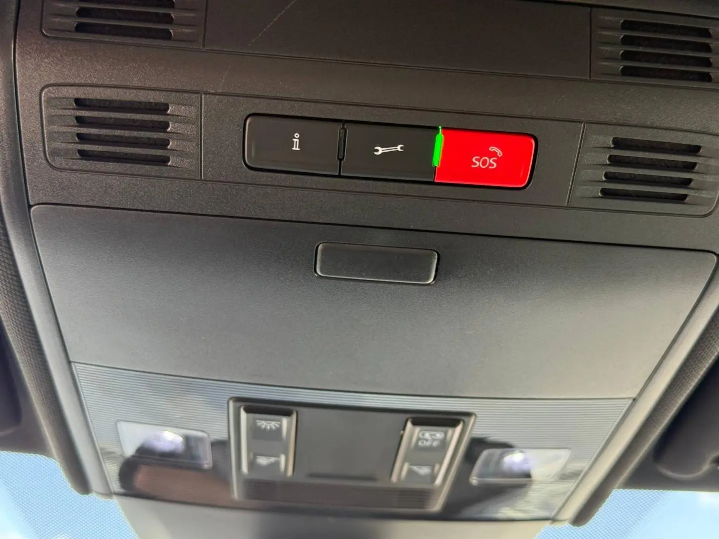 Vue en contre-plongée du plafonnier noir avec boutons SOS et commandes d’éclairage intérieur du Volkswagen Taigo gris.
