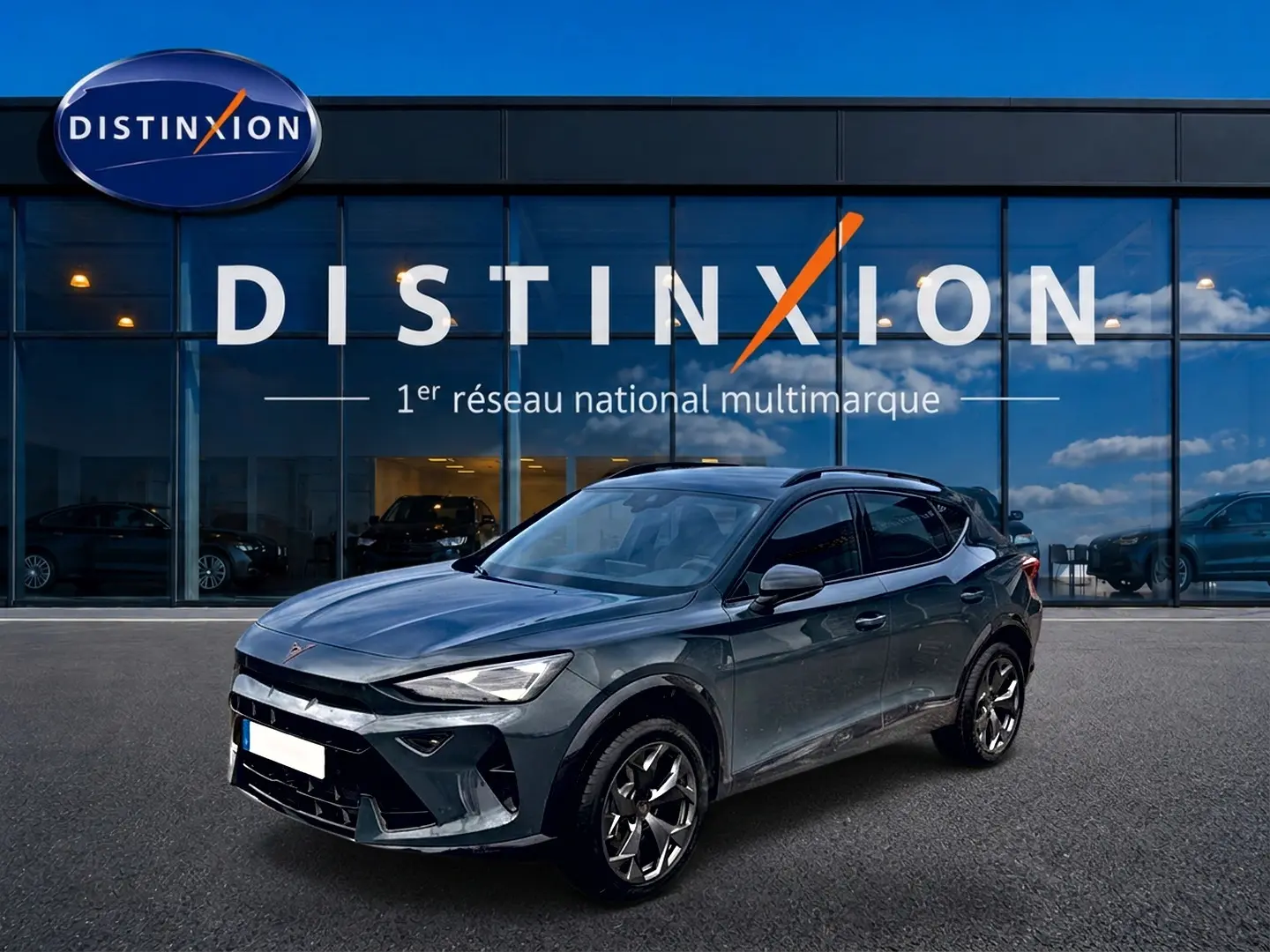 Vue 3/4 avant droite d'un CUPRA Formentor 1.5 etsi hybrid bleu fjord avec jantes 18 pouces devant un showroom Distinxion.