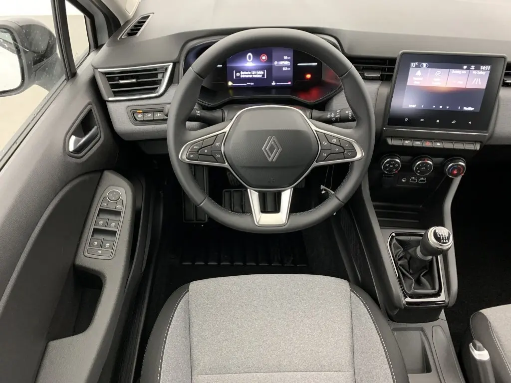 Vue intérieure centrée sur le volant et tableau de bord de la Renault Clio V TCE 90, avec boîte manuelle et écran tactile.