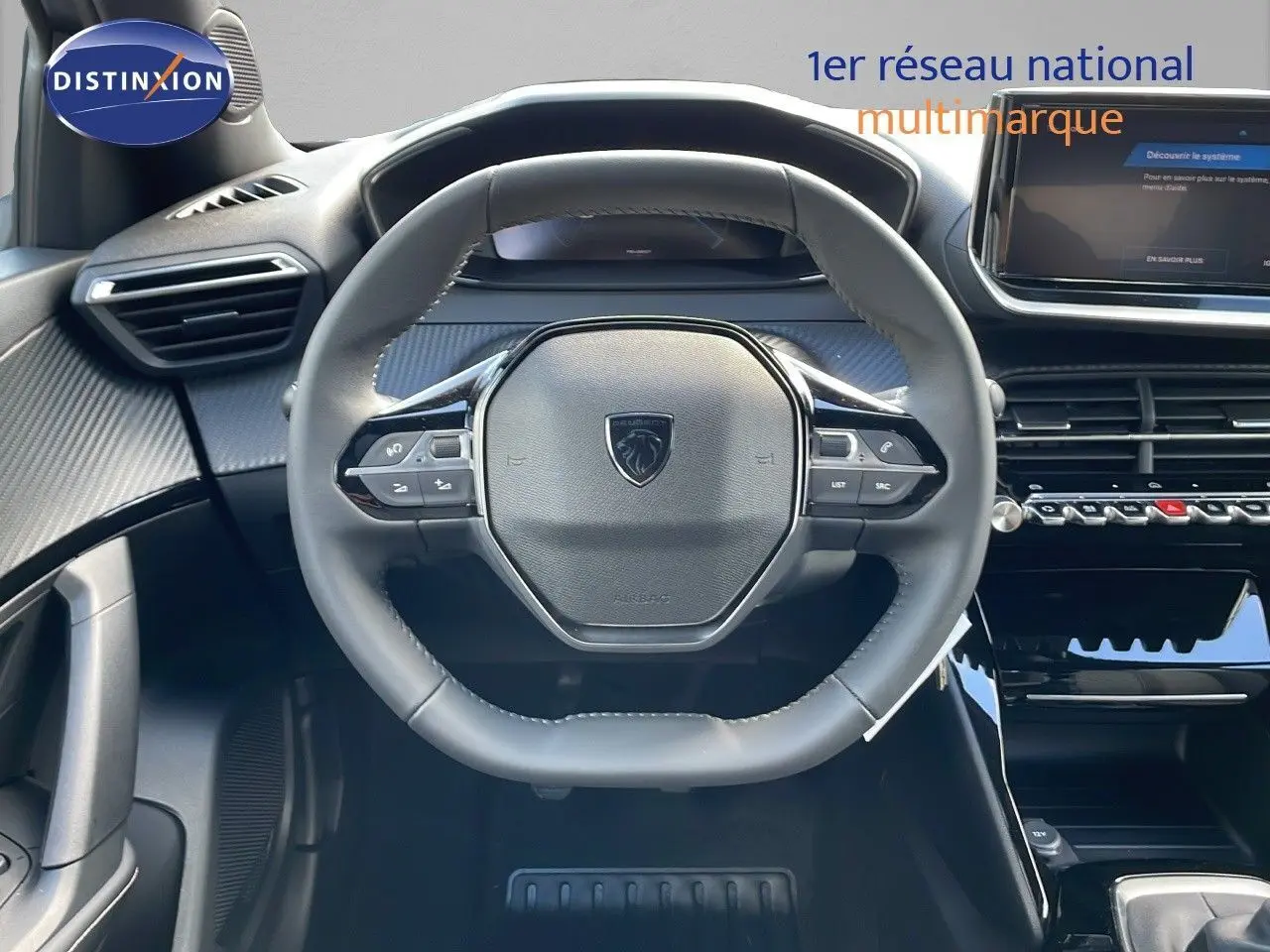 Vue centrée sur le volant cuir noir du Peugeot 2008 gris Artense, avec tableau de bord et écran tactile visibles.