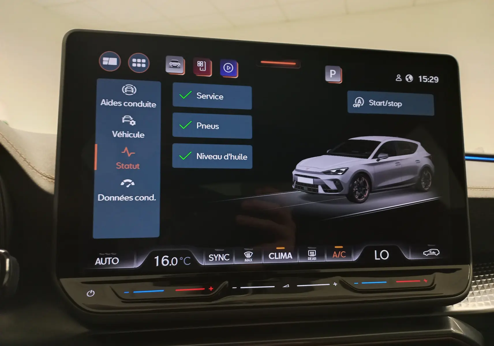 Écran tactile intérieur affichant une modélisation 3/4 avant d'une CUPRA Leon blanche Nevada avec menu de statut véhicule.