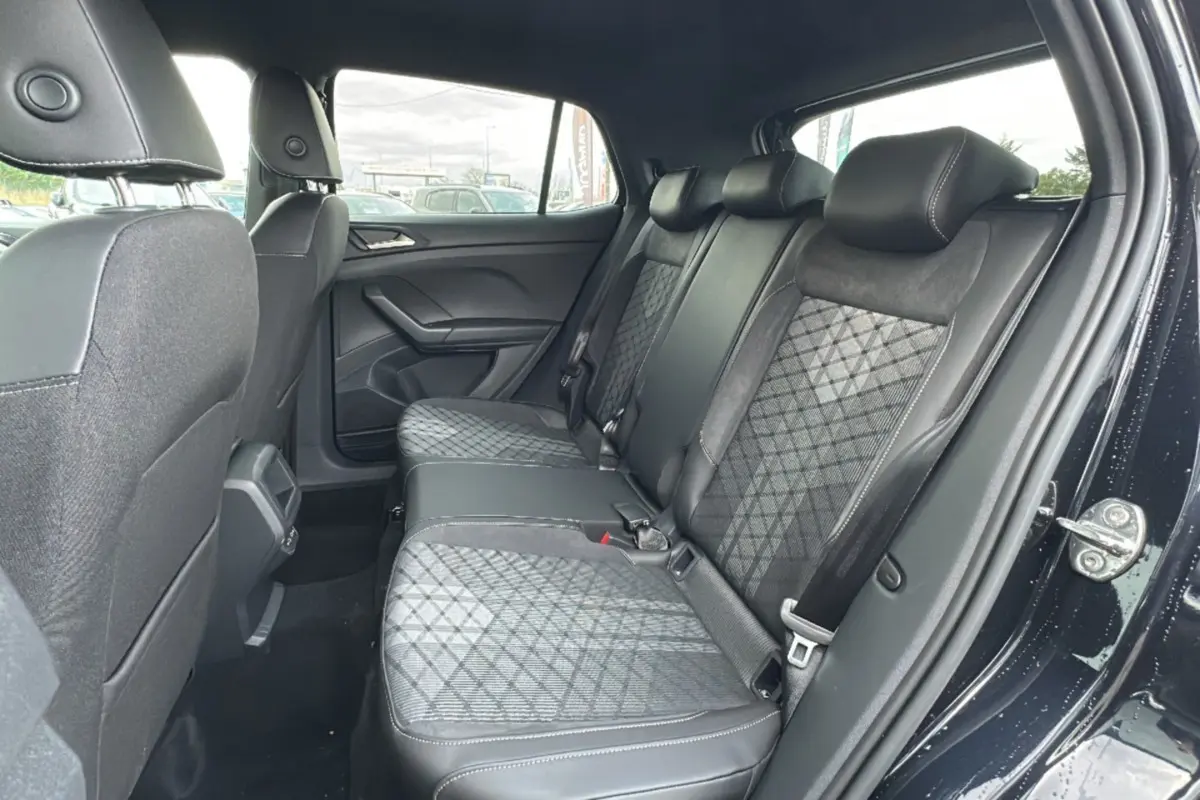 Vue intérieure côté droit sur la banquette arrière en tissu noir avec motifs géométriques du Volkswagen T-Cross noir intense 2025.