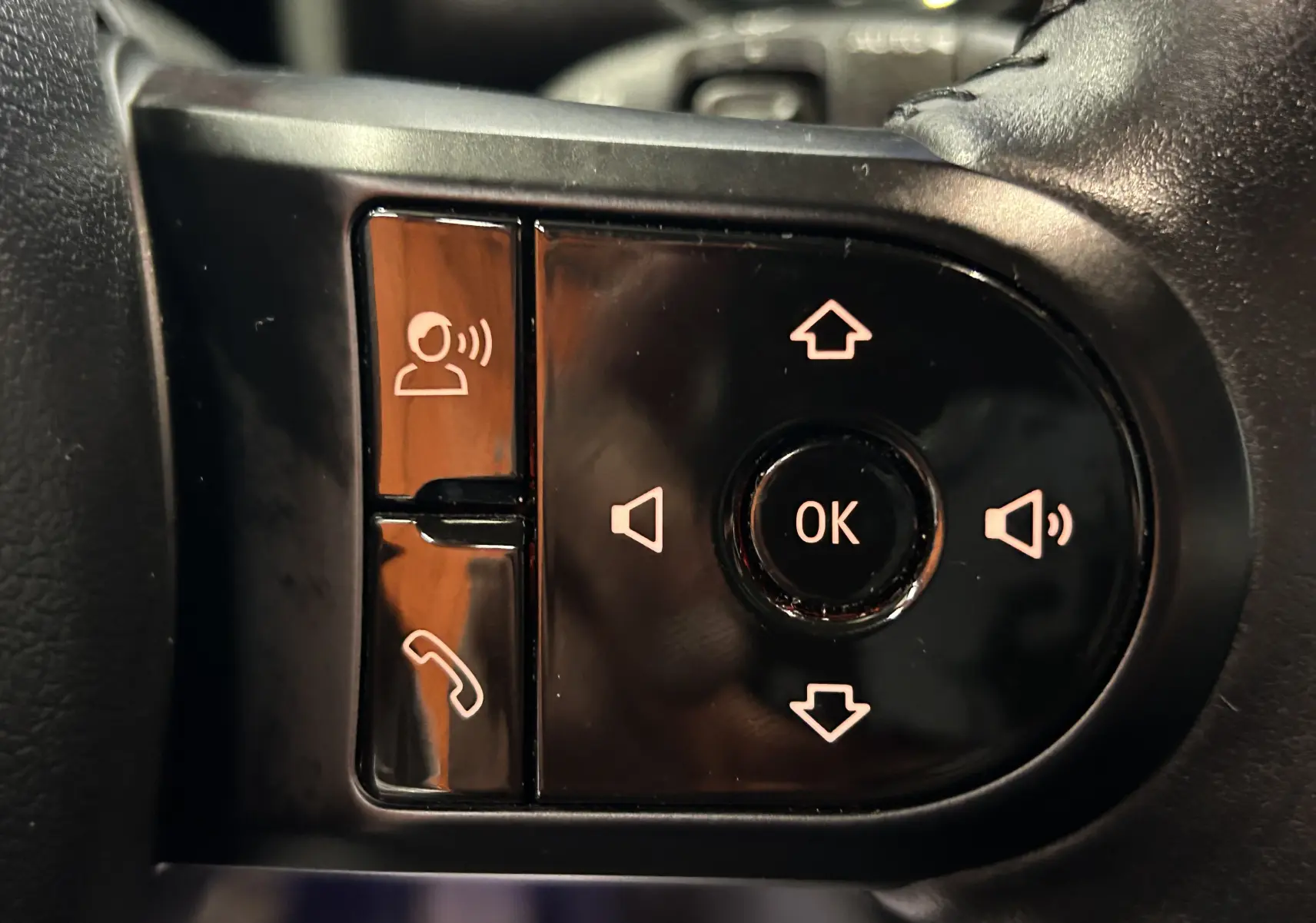 Gros plan sur les commandes noires du volant de la MINI Countryman 2021, boutons pour appels et réglages audio.