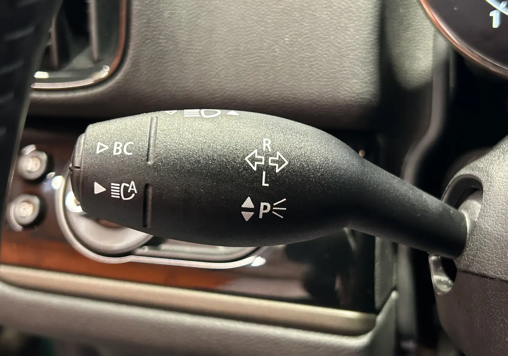 Gros plan sur la manette de clignotants noire à gauche du volant dans l'habitacle du MINI Countryman 2021.