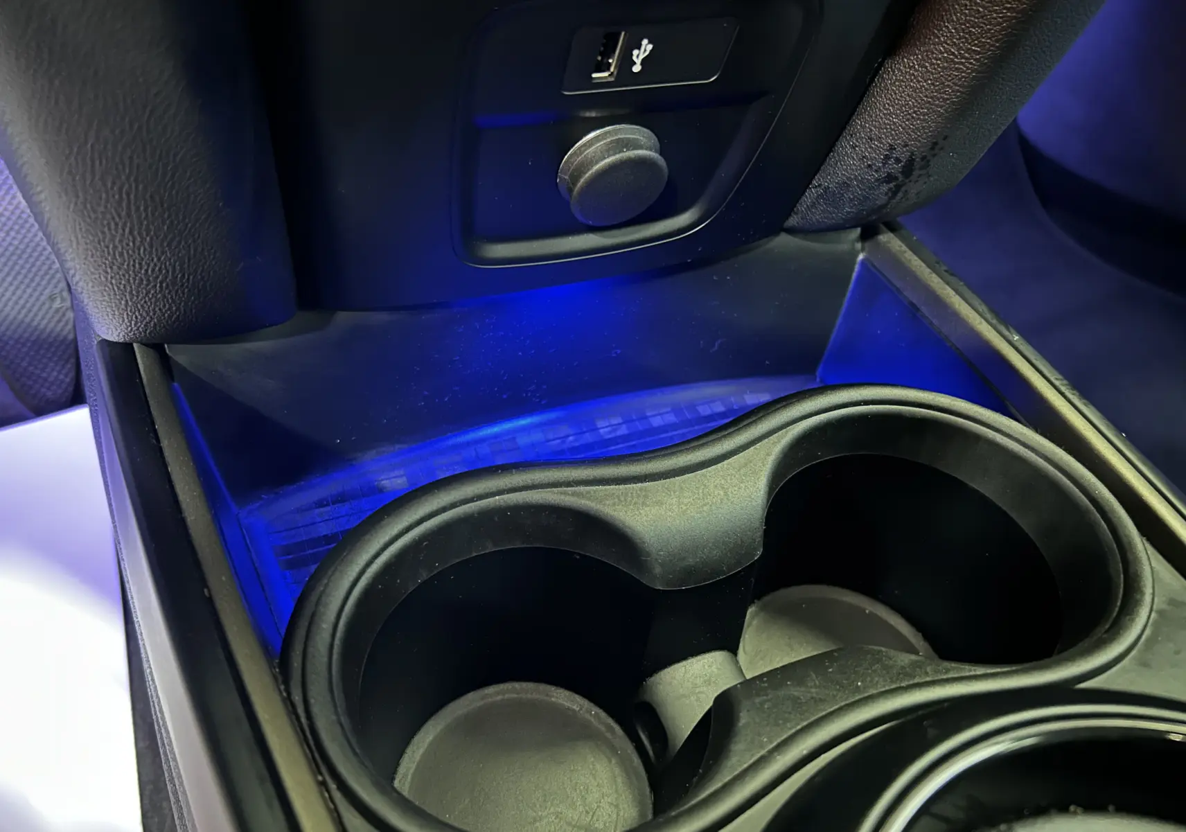 Gros plan sur les porte-gobelets et prise USB arrière avec éclairage bleu intérieur d’un MINI Countryman 2021.