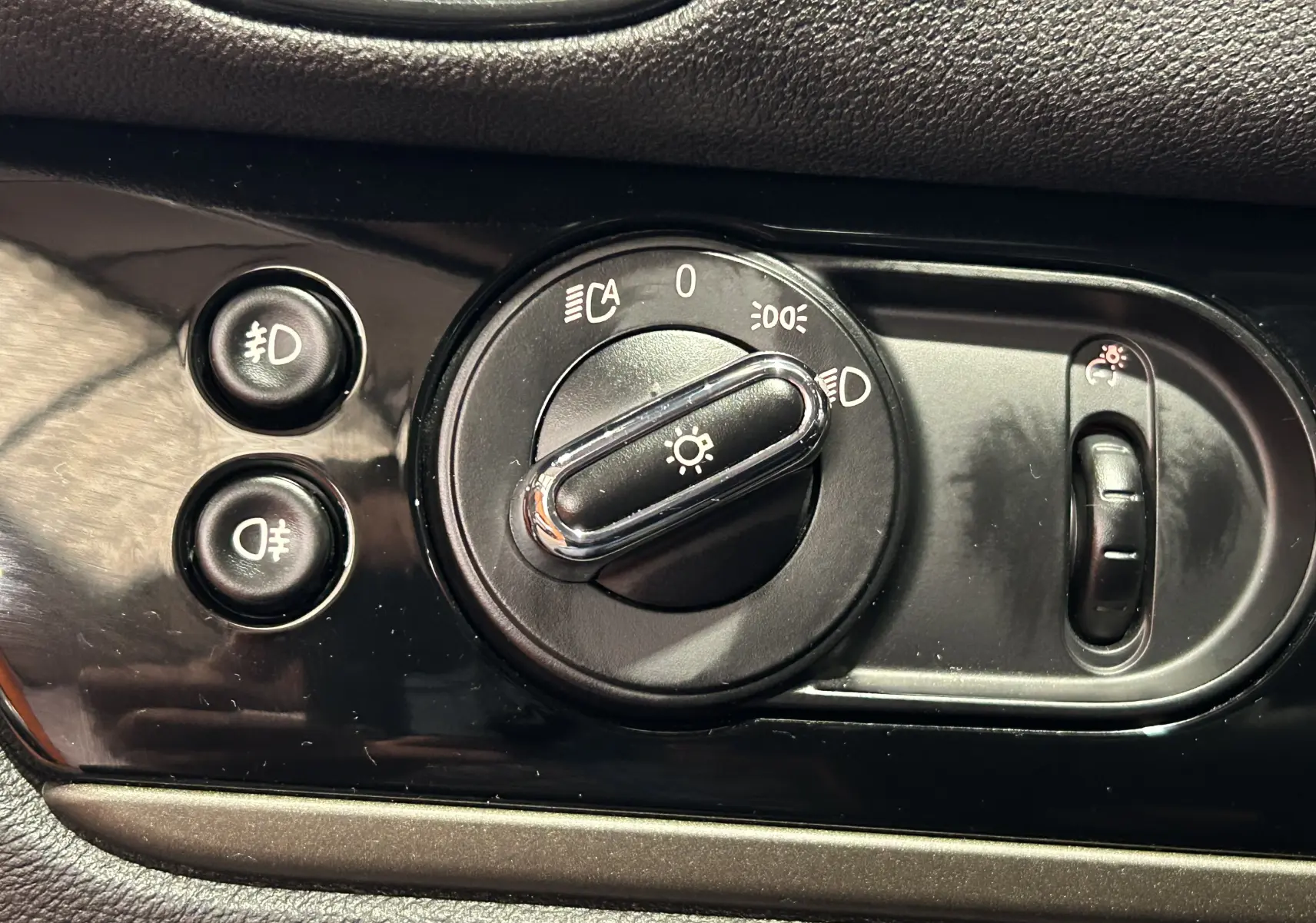 Gros plan sur la commande d’éclairage noire du tableau de bord d’une MINI Countryman 2021.