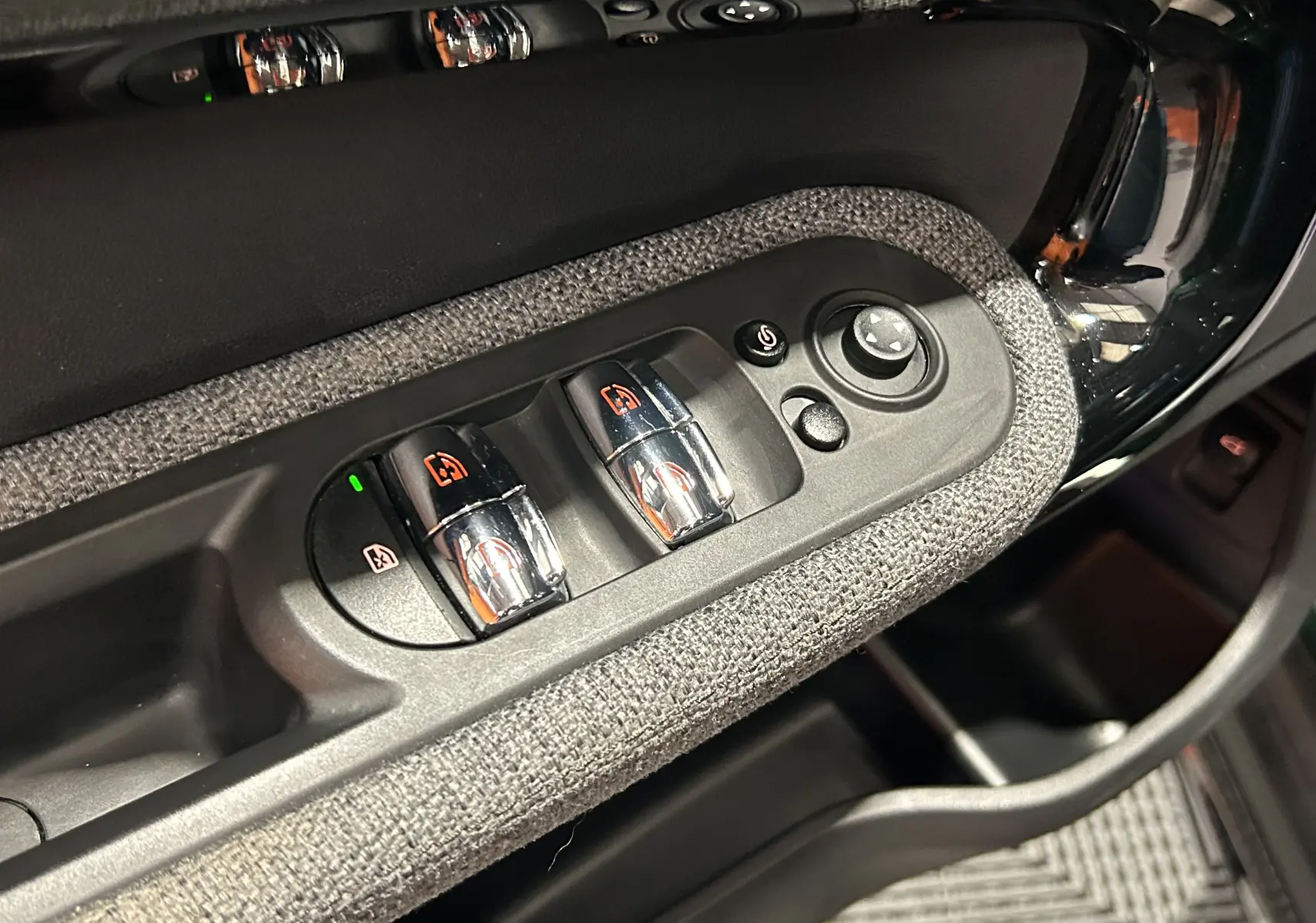 Détail des commandes de lève-vitres et réglage des rétroviseurs sur la porte côté conducteur d’un MINI Countryman 2021.