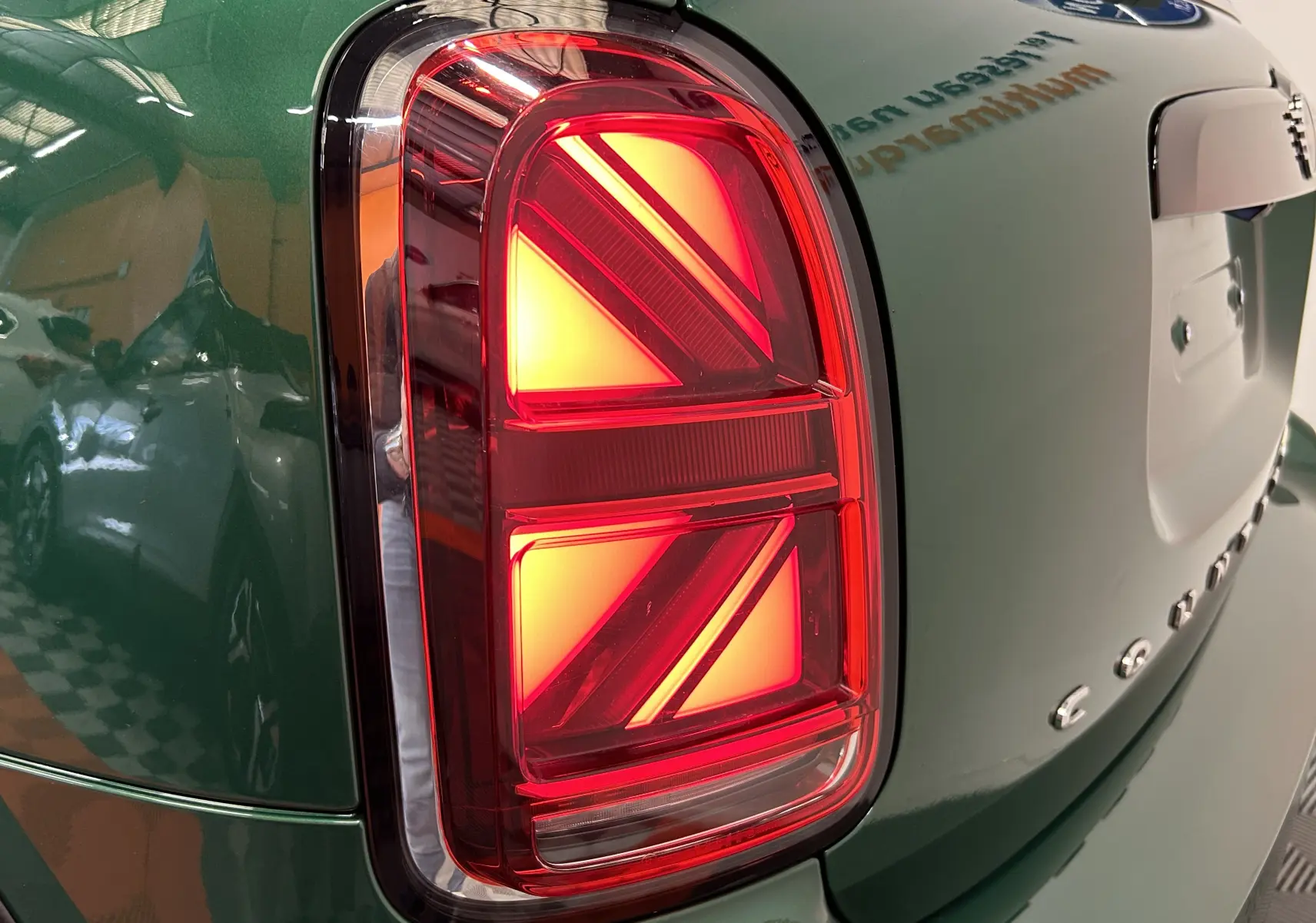 Gros plan sur le feu arrière gauche rouge avec motif Union Jack du MINI Countryman vert métallisé 2021.