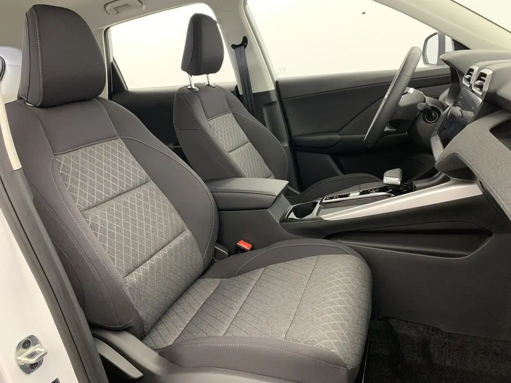 Vue intérieure côté gauche du poste de conduite du MG ZS 1.5L Hybrid+ 2026 avec sièges tissu gris et noir.