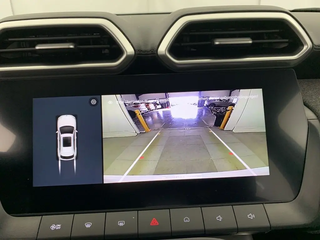 Écran central du MG ZS blanc montrant la caméra de recul avec vue arrière et affichage 3D du véhicule.