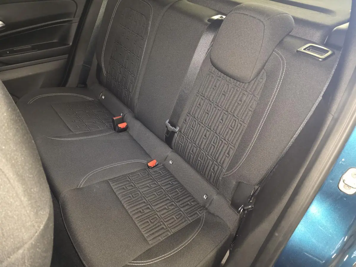 Vue intérieure côté droit sur la banquette arrière noire avec motifs FIAT, porte bleue métallisée ouverte visible.