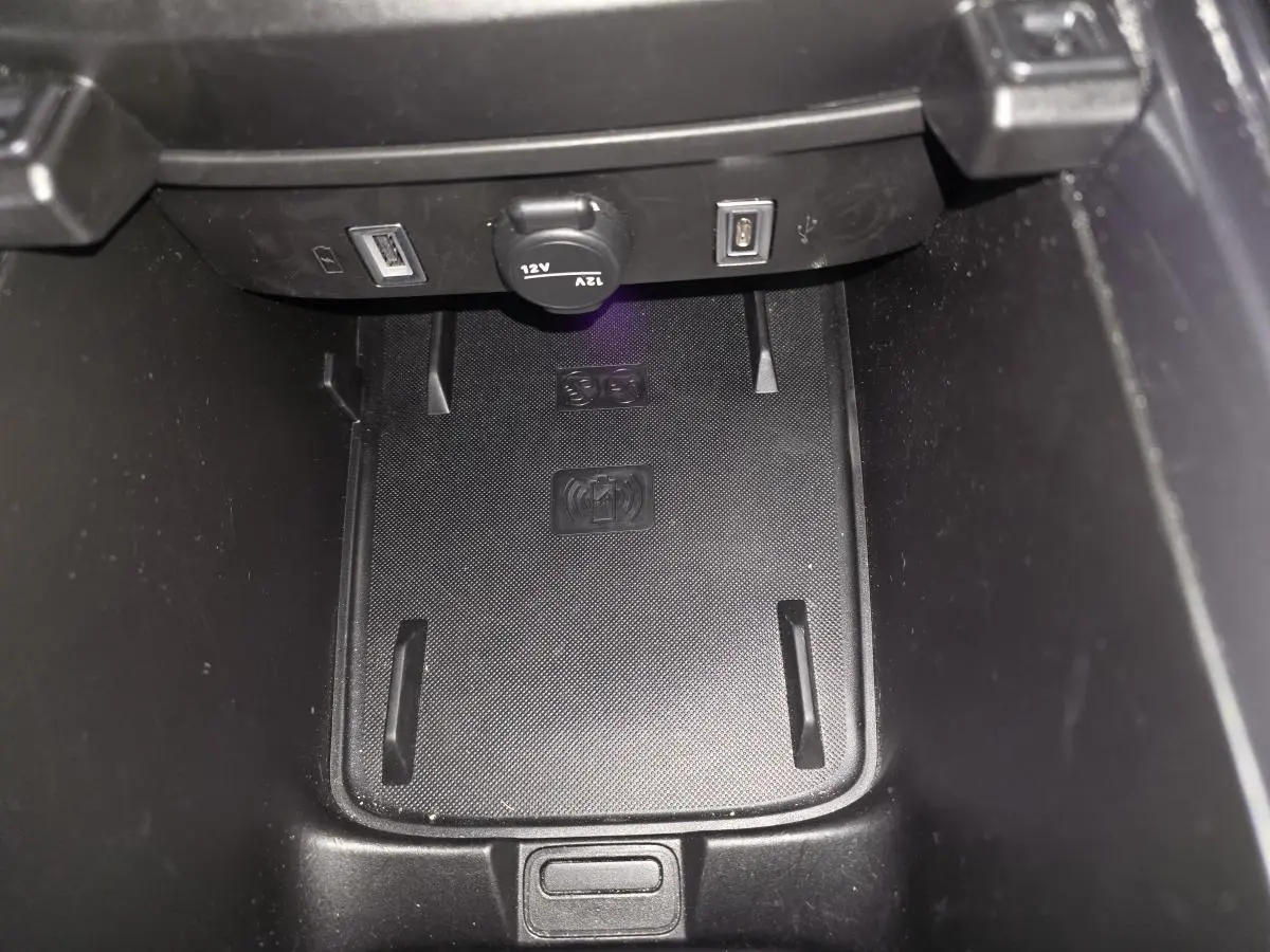 Gros plan sur le chargeur à induction et ports USB dans la console centrale de la FIAT 600 Hybrid bleu 2025.