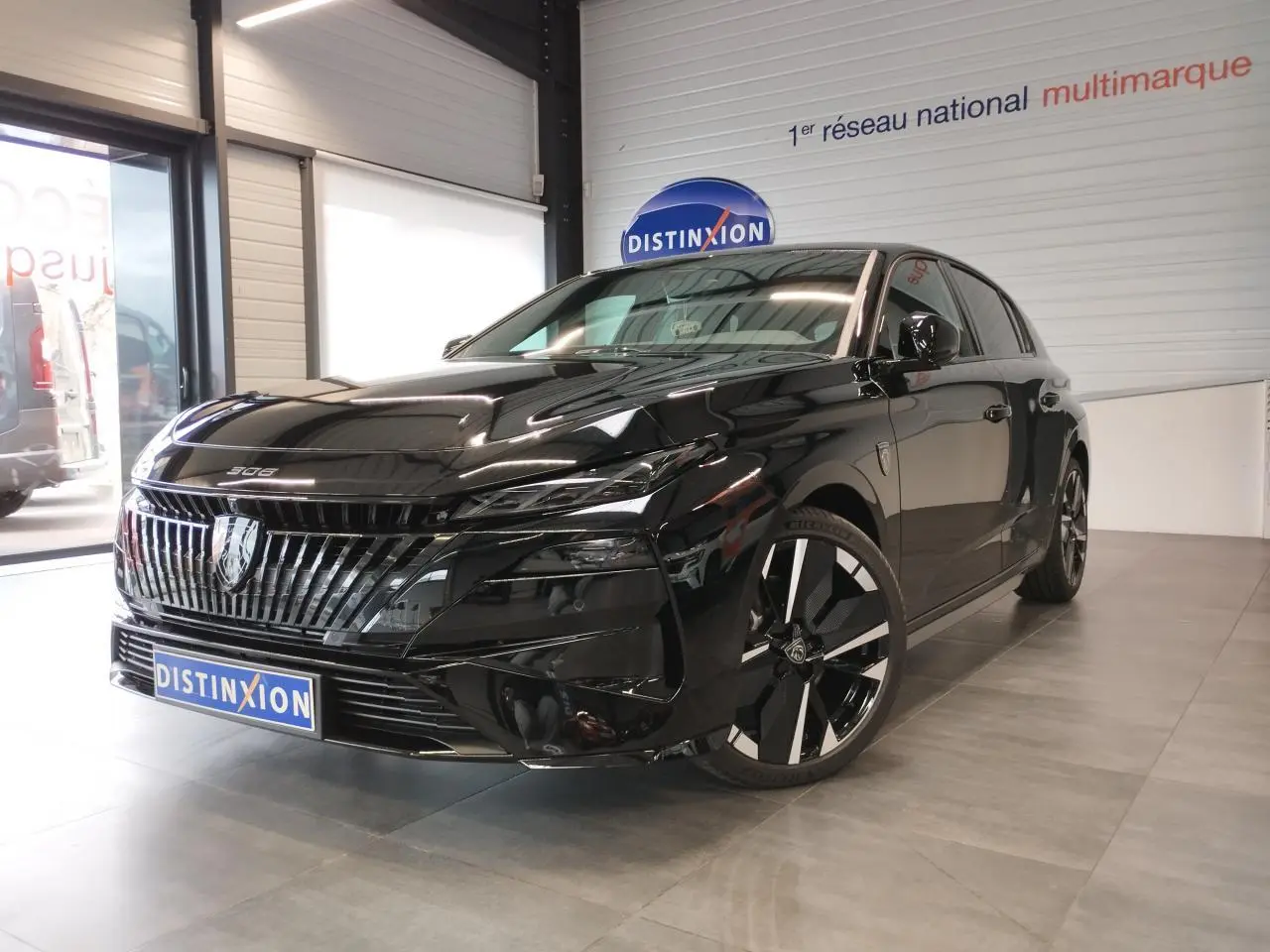 Peugeot 308 hybride noir métallisé vue 3/4 avant droit, avec calandre et jantes alliage distinctives.