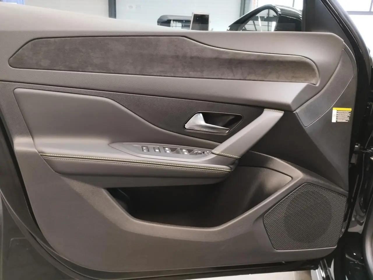 Porte avant droite de Peugeot 308 1.2i Hybrid noire, avec garniture en similicuir et alcantara, commandes électriques et haut-parleur intégré.