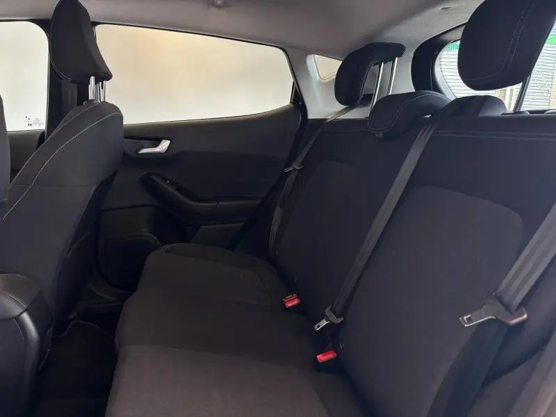 Vue latérale droite de l'intérieur arrière de la Ford Fiesta 2022, sièges noirs avec ceintures de sécurité visibles.