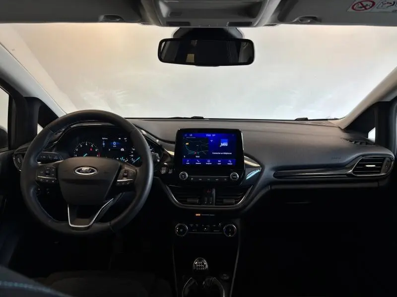 Vue intérieure frontale du tableau de bord de la Ford Fiesta 2022 avec écran tactile et volant multifonction noir.