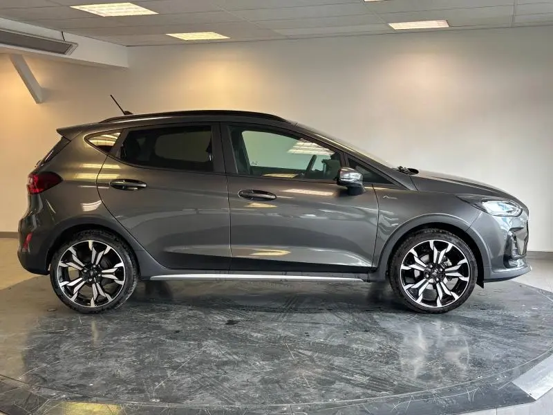Profil droit d'une Ford Fiesta 2022 en gris Fashion Magnetic avec jantes alliage 18 pouces et becquet arrière.