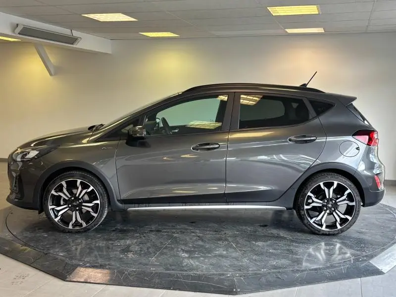 Profil côté gauche d'une Ford Fiesta 2022 gris Fashion Magnetic avec jantes alliage 18 pouces cinq branches en Y.