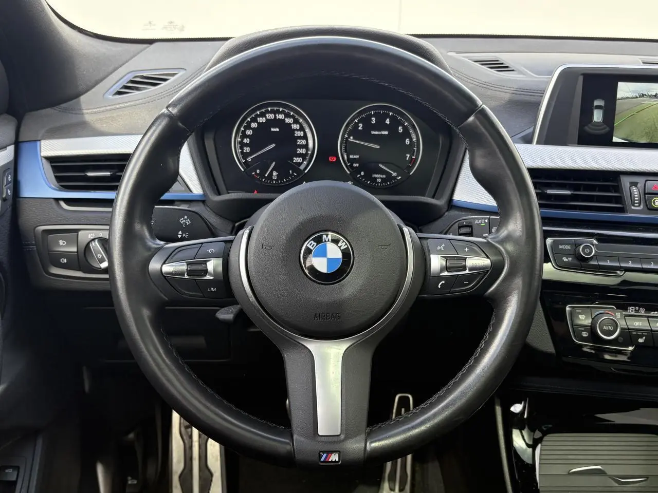 Vue frontale du volant cuir M et tableau de bord noir de la BMW X2 F39 avec écran multimédia et commandes intégrées.