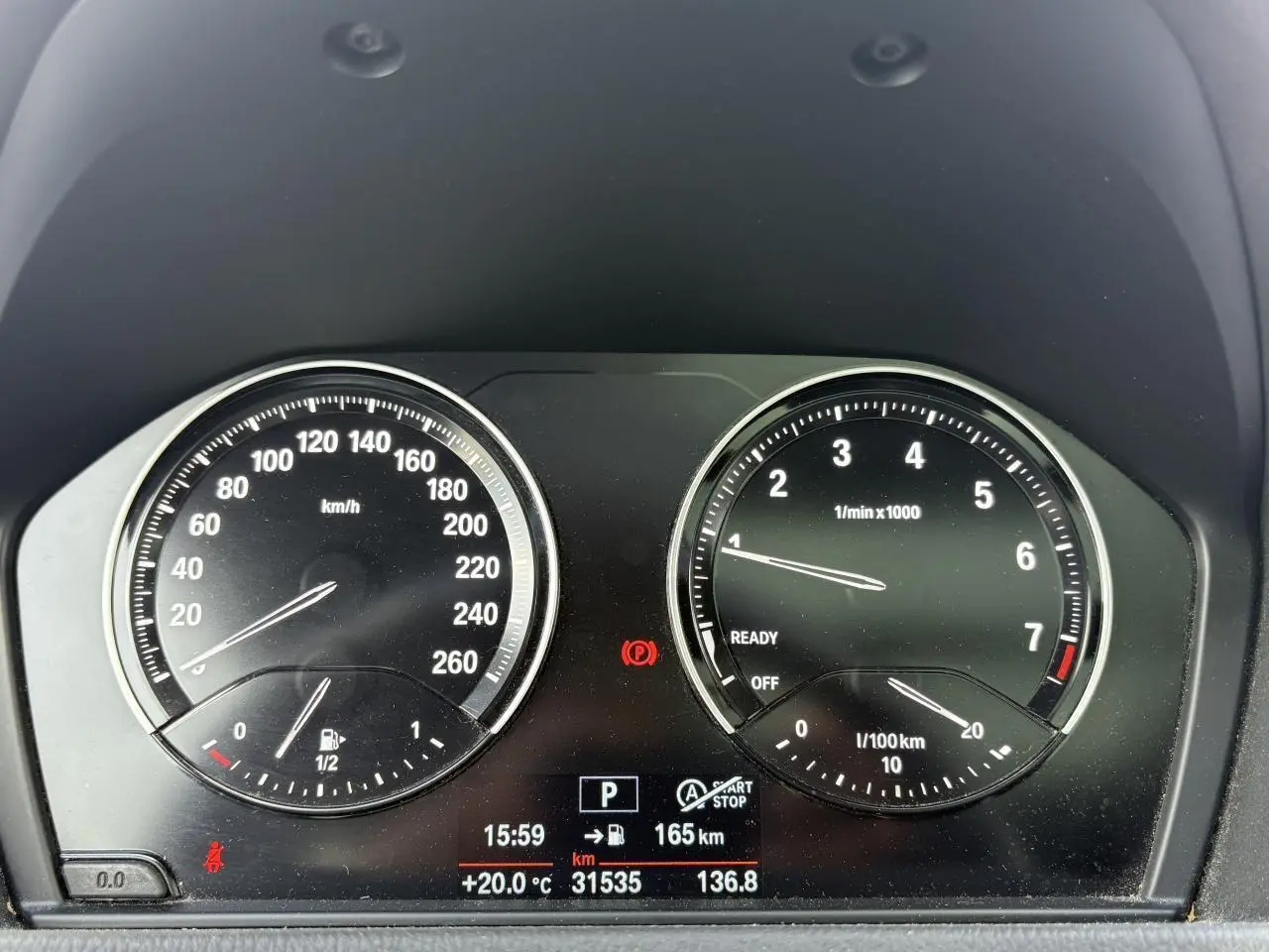 Tableau de bord de BMW X2 blanc, affichant compte-tours et compteur de vitesse avec écran digital central.