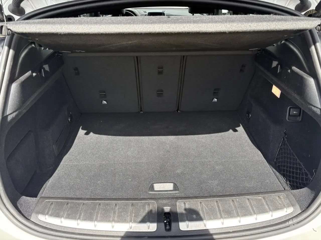 Coffre ouvert d'un BMW X2 blanc alpin (F39) montrant un espace de chargement propre et bien agencé.