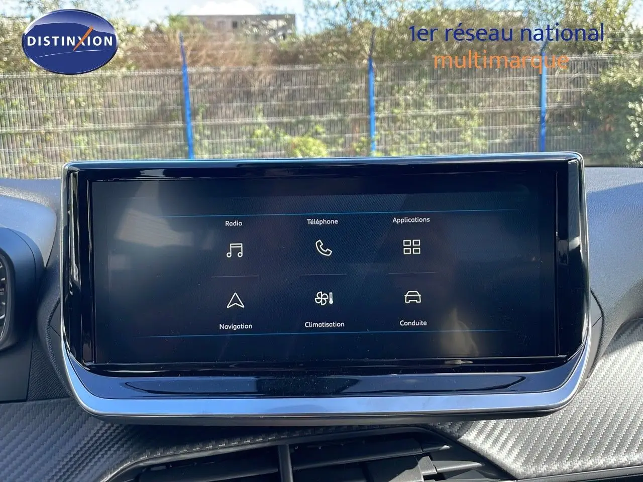 Écran tactile central du tableau de bord du Peugeot 2008 2025, avec interface multimédia affichée en extérieur.