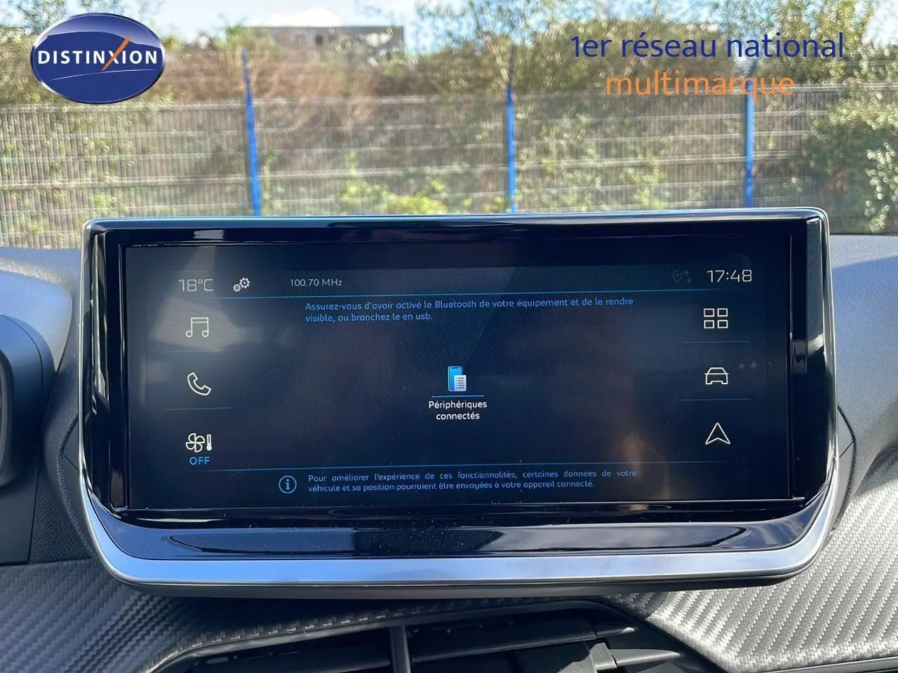 Écran tactile central du Peugeot 2008 blanc Okenite Metal, affichant les options connectées et la température extérieure.